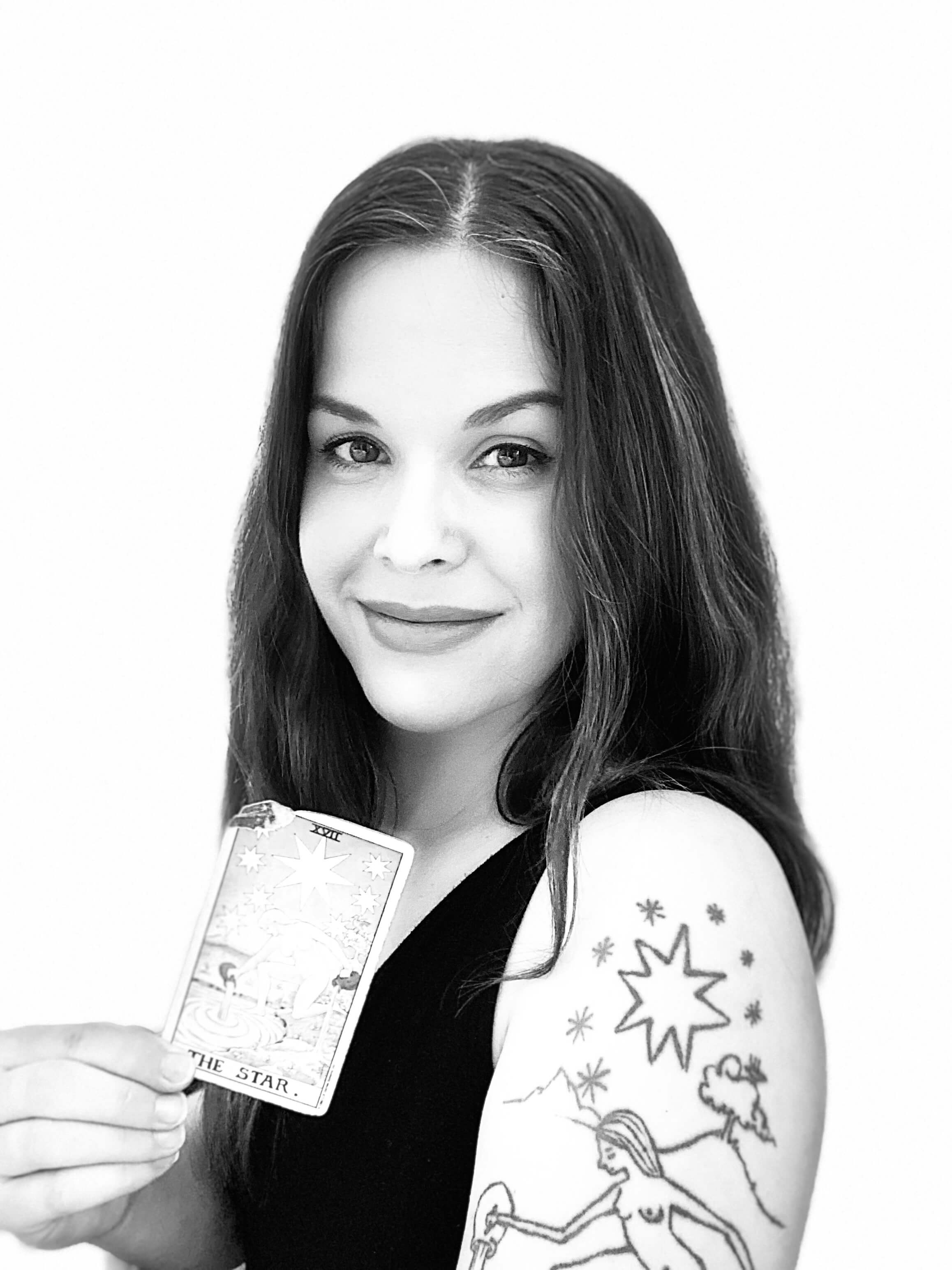 Nora Christine Wallace, psychic tarot reader and shamanic journey guide, holding The Star tarot card